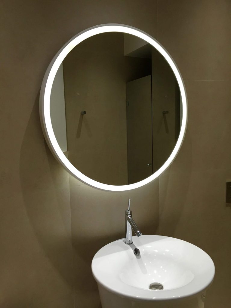 Miroir lumineux devant un lavabo blanc moderne et design